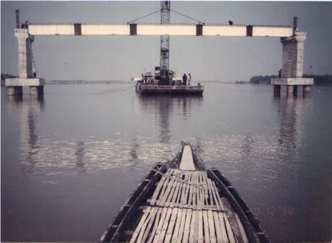 Steel launching gantry spanning bridge piers over a river